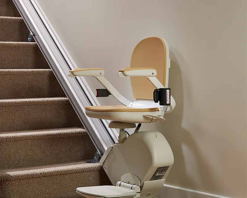 Acorn 130 stairlift beside a straight staircase, showing the chair and rail